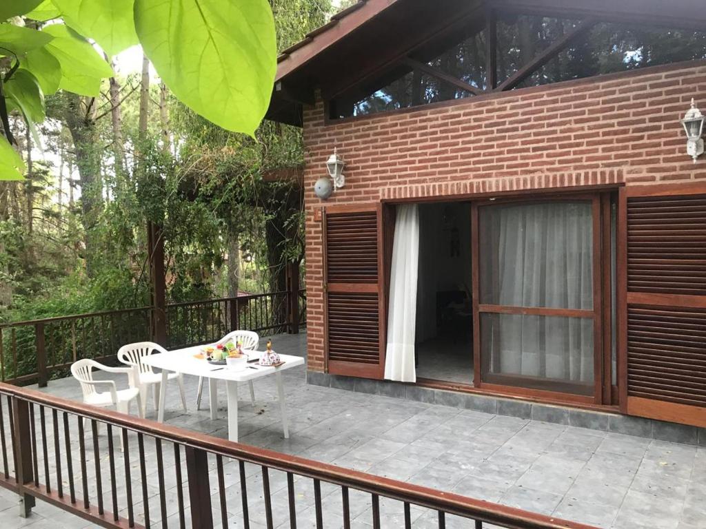 a patio with a table and chairs on a balcony at Casa Encanto in Mar de las Pampas