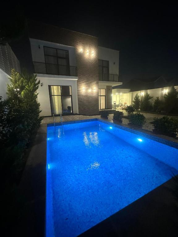 a swimming pool in front of a house at night at Villa Mardakan in Mərdəkan