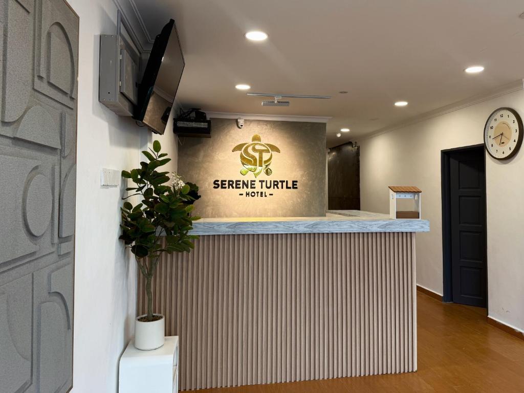 an office with a reception counter with a sign on the wall at Serene Turtle Hotel in Kuala Terengganu