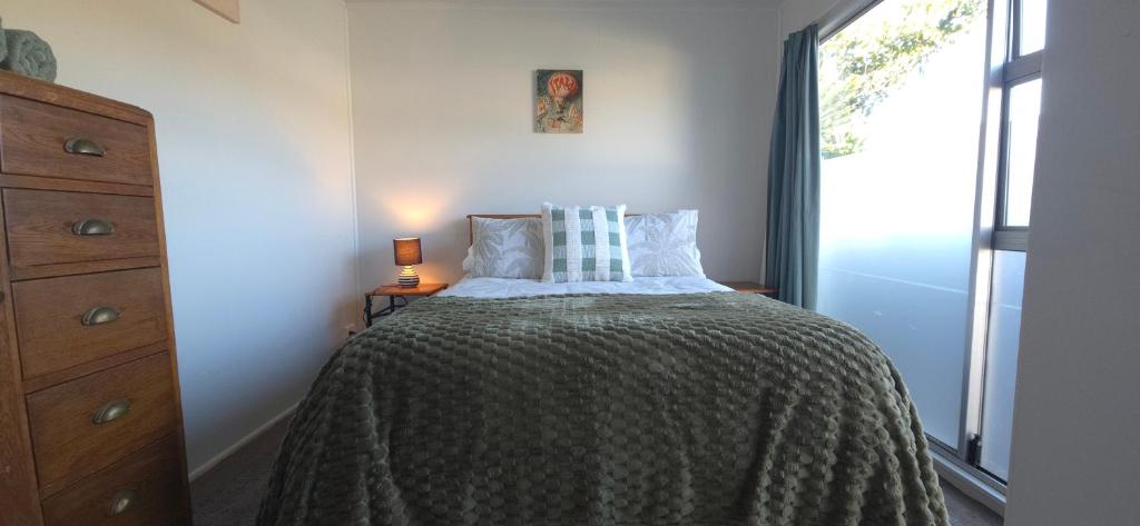 a bedroom with a bed and a window at Cozy corner on Cohen in Nelson