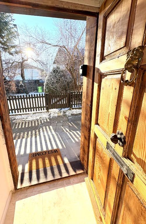 an open wooden door with a view of a patio at Zentrale Wohnung in Garmisch mit Zugspitzblick in Garmisch-Partenkirchen