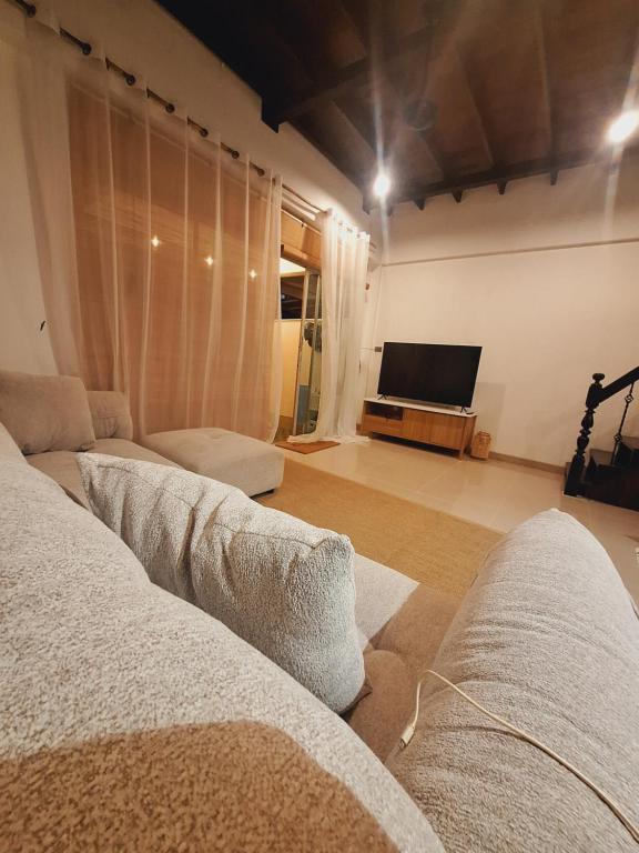 a living room with two couches and a flat screen tv at The Lighthouse Seaview Hotel in Rawai Beach