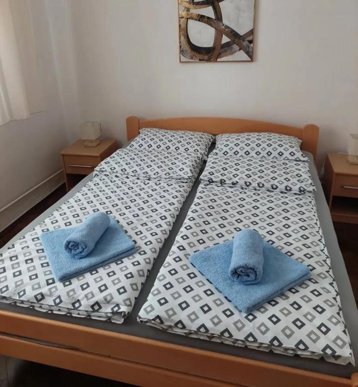 a bed with two blue towels sitting on it at msapartman in Surčin