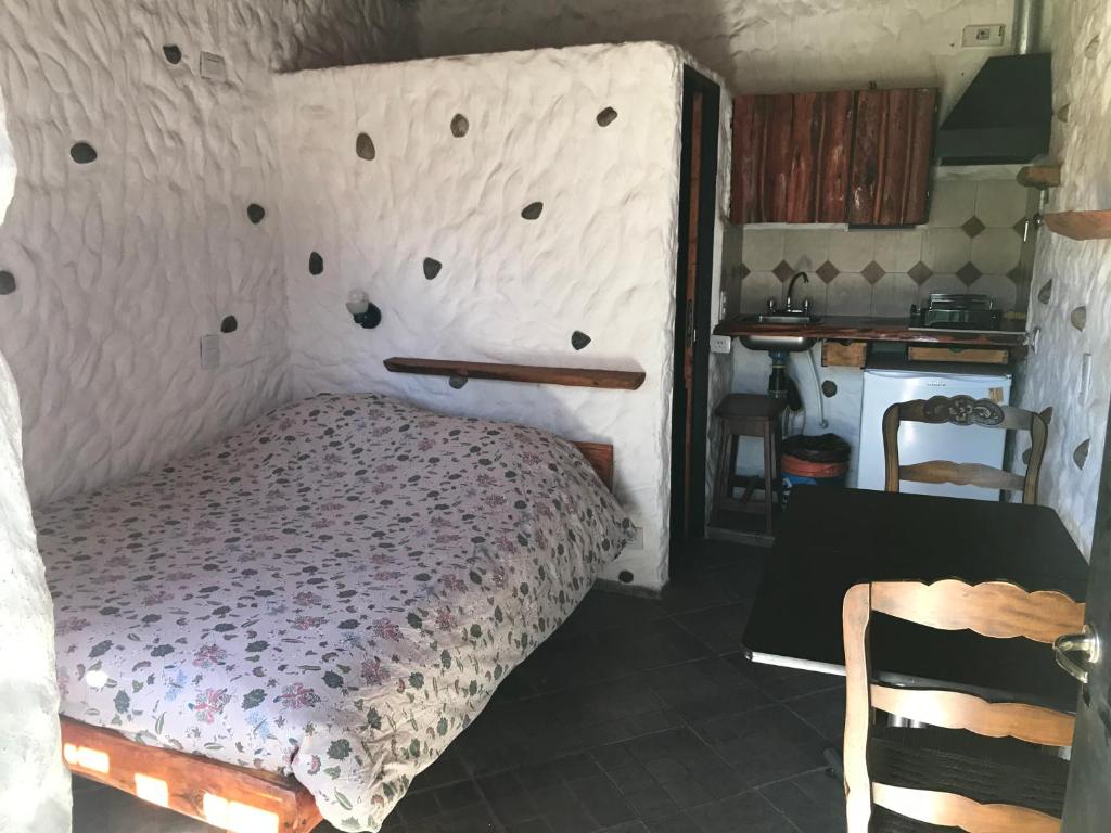 a bedroom with a bed with a wall with holes at Cabaña Tío Ale MONOAMBIENTES in El Bolsón
