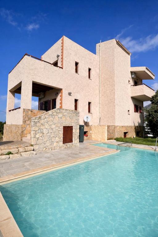 a house with a swimming pool in front of a building at Villa Evenos with private pool in Elafonisi