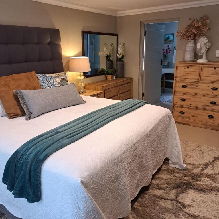 a bedroom with a large bed and a dresser at Kruger Tree Lodge in Marloth Park