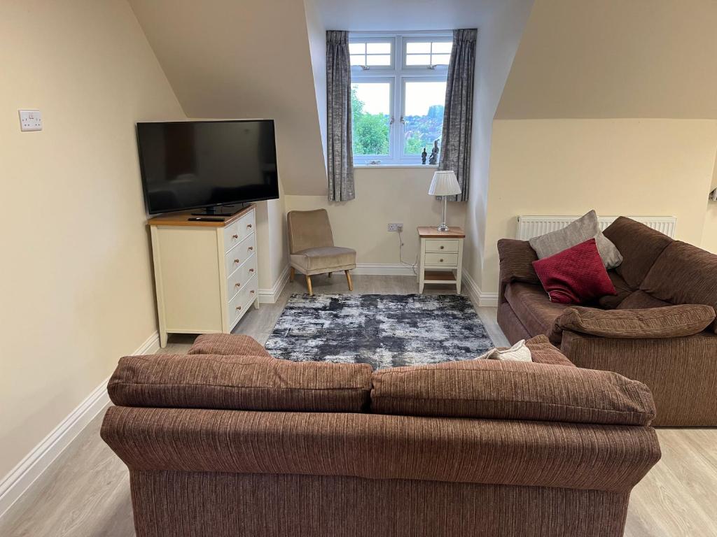 a living room with two couches and a flat screen tv at Quiet studio flat near University & QMC, King size bed in Nottingham