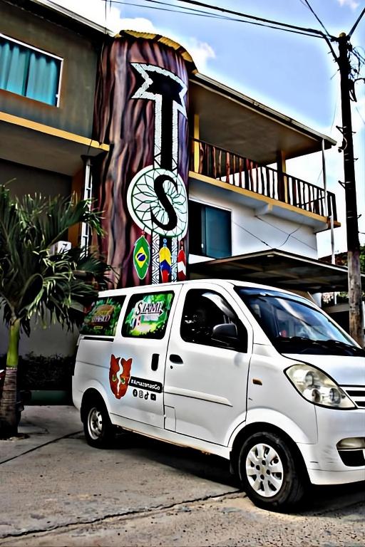 a white car parked in front of a building at Hotel & Restaurante Siami in Leticia