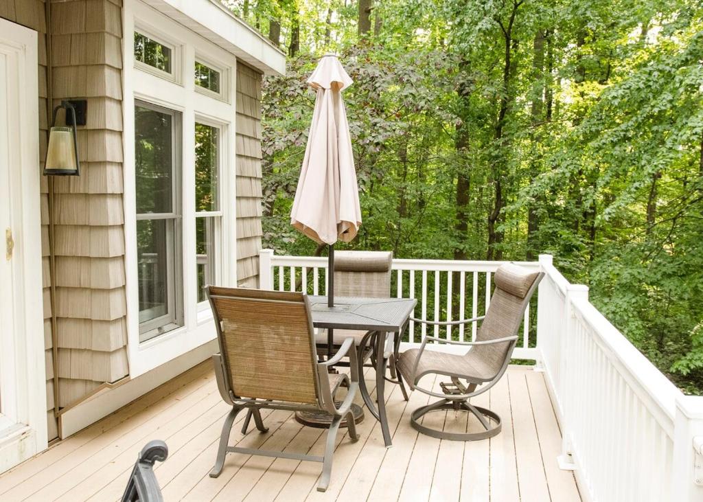 a porch with a table and chairs and an umbrella at Family-Friendly Strasburg Escape | 50 Mile Views in Strasburg