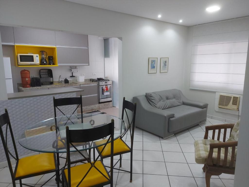 a kitchen and living room with a table and a couch at Recanto da Enseada in Guarujá