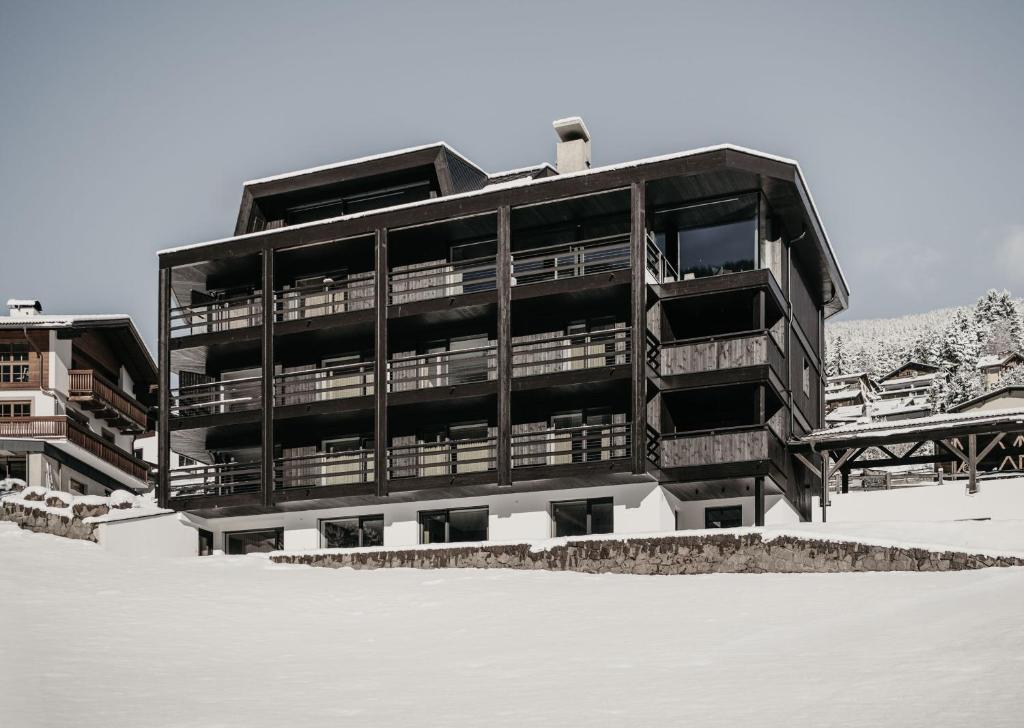 a large building with snow on the ground at Dolomites Chalet Niuasi in Ortisei