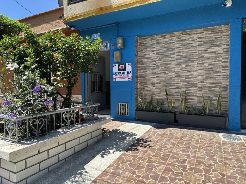 a blue building with a sign on the door at LAS CAMELIAS APARTAHOTEL - La Virginia Risaralda in La Virginia