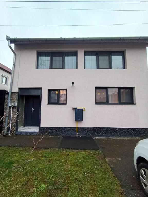 a white house with black windows at Casa Pop in Oradea