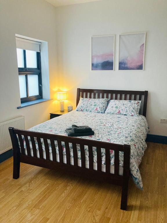 a bedroom with a large bed with a wooden floor at 2 Bedroom Workers Apartment in Barrysbrook