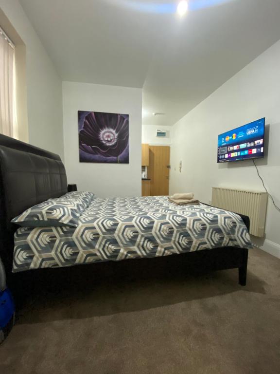 a bedroom with a bed with a comforter on it at Comfy private studio Moseley in Birmingham