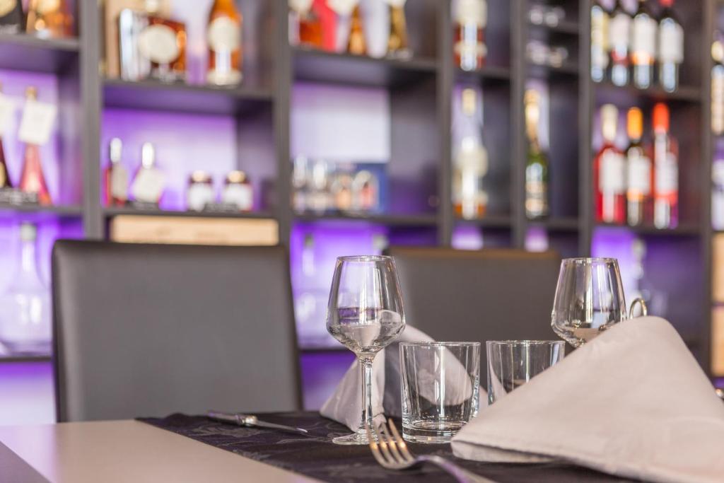 a table with wine glasses and napkins on it at Hôtel Restaurant de l'Ecu in Jonzac