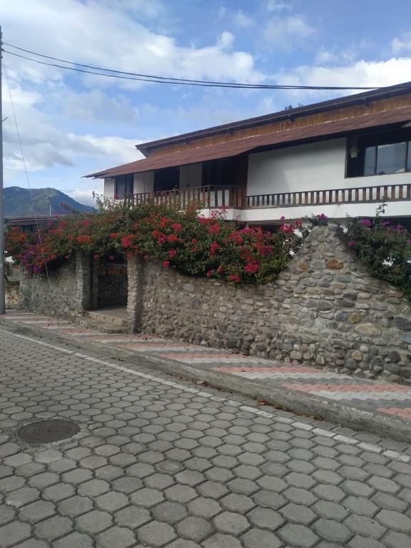 a building with flowers on a stone wall at Casa de campo Las Flores in Penipe