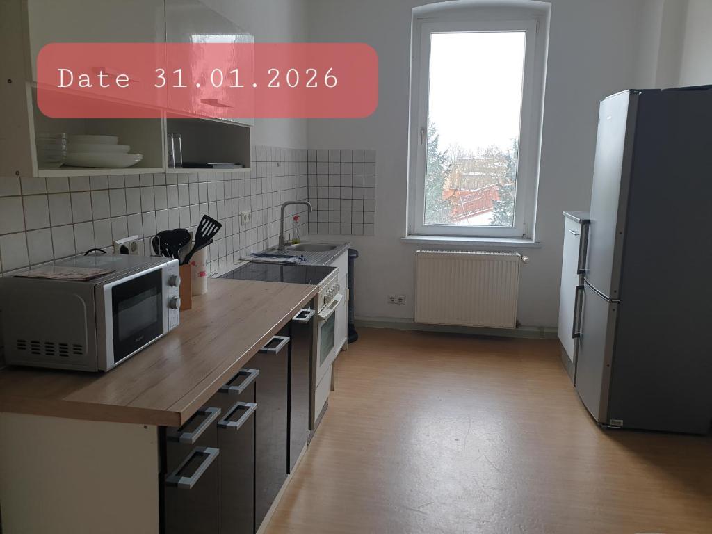 a kitchen with a counter with a microwave and a refrigerator at Monteurwohnung bei Nina 1OGL in Zeitz