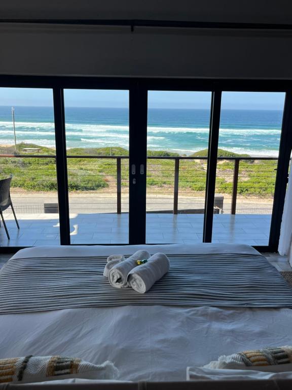 a bedroom with a bed with a view of the ocean at Oppi See Beach House in Wilderness