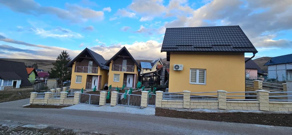 a house with a black roof on a street at Zekića konaci in Ljubiš