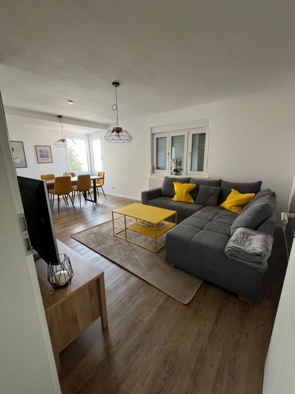 a living room with a gray couch and yellow pillows at Ellis Häusle in Nagold