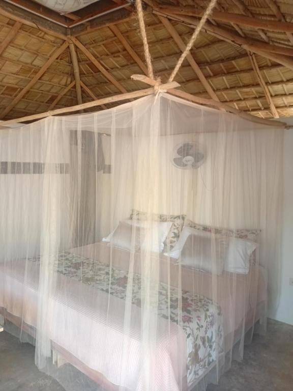 a bedroom with a canopy bed with white curtains at EL Cielo de Cana in Las Terrenas