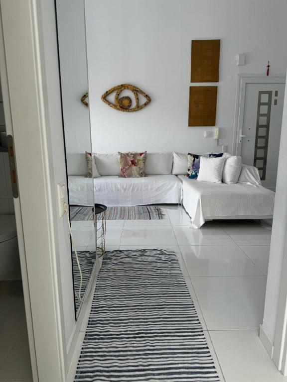 a living room with a couch and a mirror at Enlightened Escape in Nea Peramos