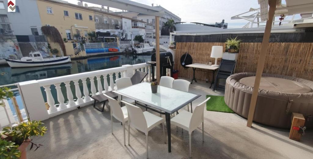 a balcony with a table and chairs and a tub at Casa con embarcadero in Los Mártires