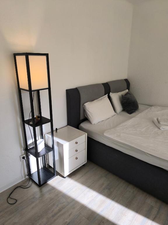 a bedroom with a bed with a night stand next to it at Central Hostel Nurnberg in Nuremberg