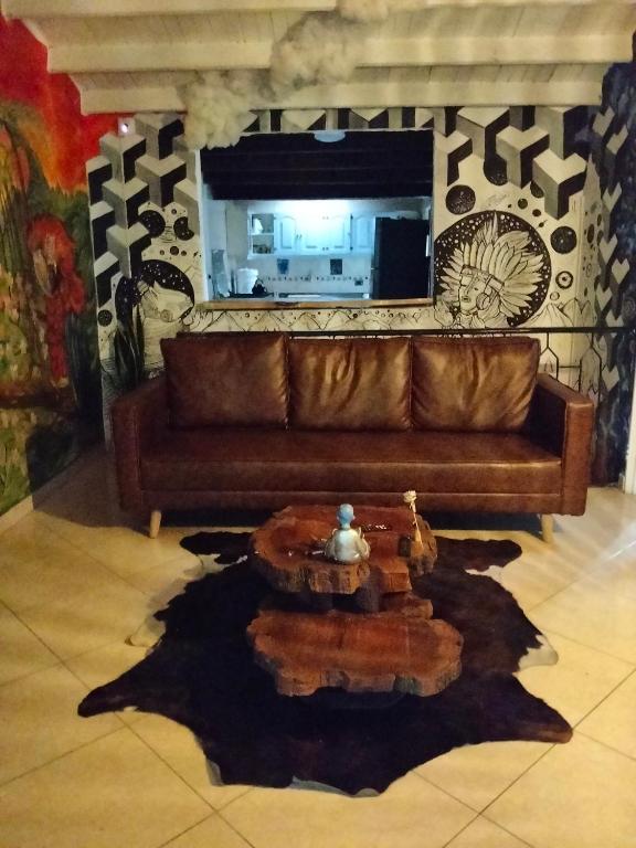 a living room with a brown couch and a table at Jungle house private room in Medellín