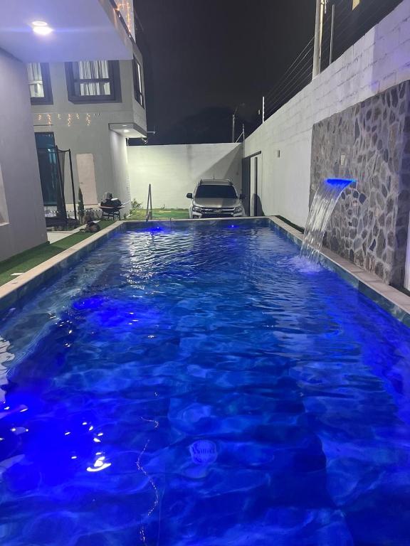 a pool with blue water and a fountain at Villa Sabanilla Casa bifamiliar campestre con piscina privada Aire acondicionado Tranquilidad total in Puerto Colombia