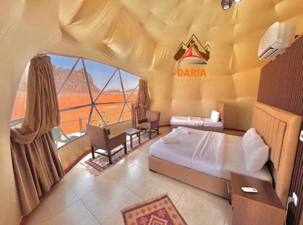 a hotel room with a bed and a large window at Daria Luxury Camp in Wadi Rum