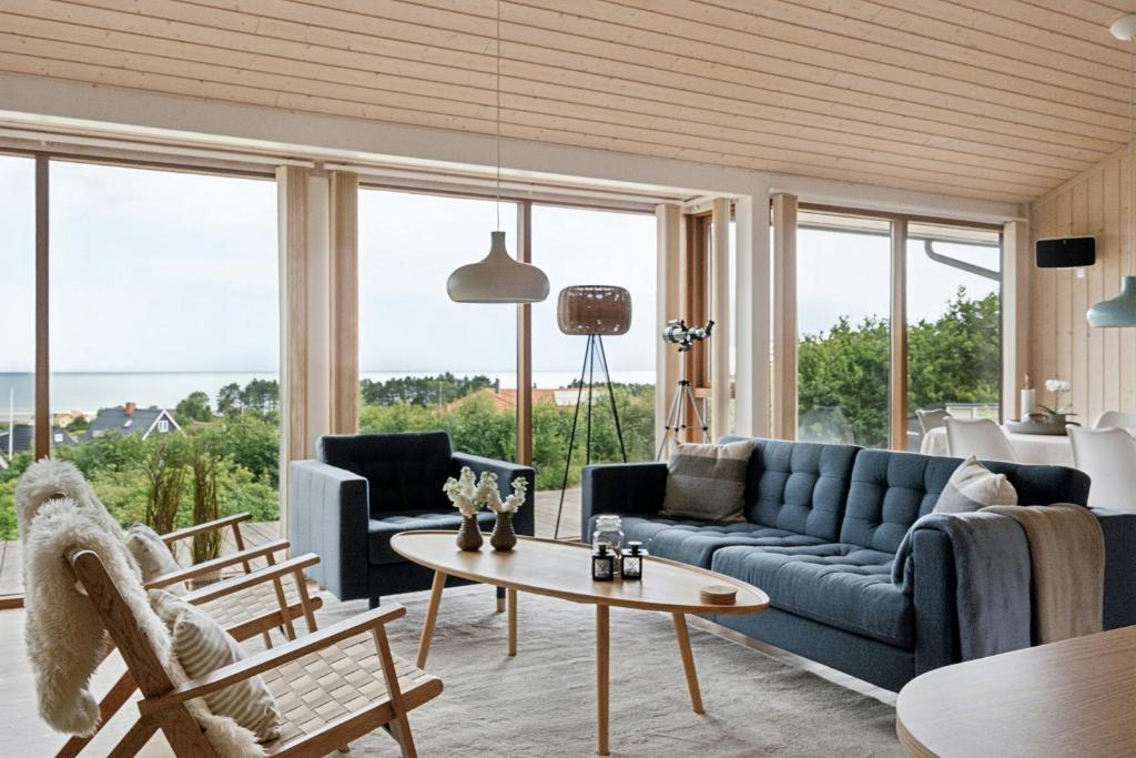 a living room with a blue couch and a table at Seaside Cottage At Bønnerup Strand in Glesborg