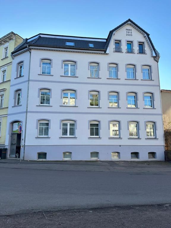a white building with windows on a street at Oppiner Straße 14 Trotha4 in Halle an der Saale