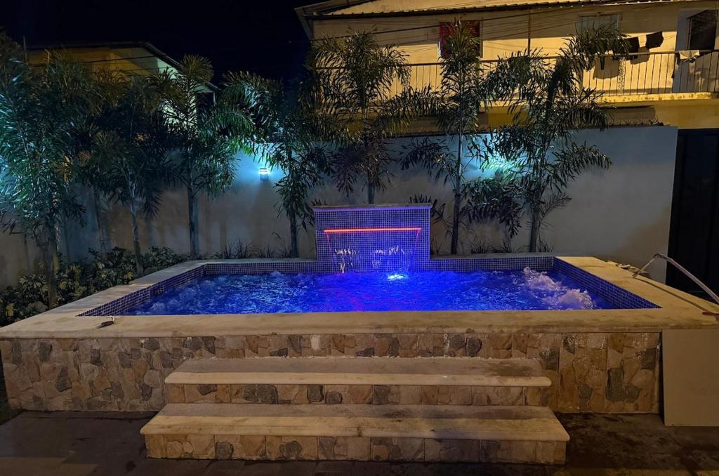 a pool in a backyard at night with lights at El rincón de Sánchez in Moca