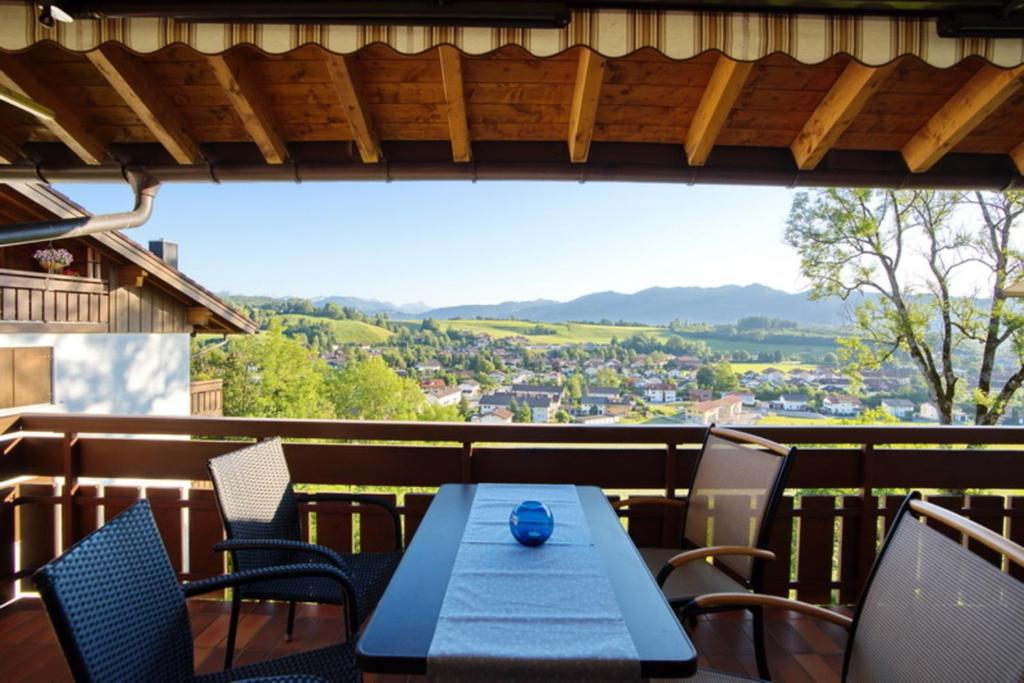 a table and chairs on a balcony with a view at StaigAllgäublick in Sonthofen