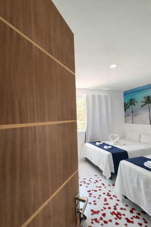 a bedroom with two beds and a sliding door at Pousada Doce Mar in Maragogi