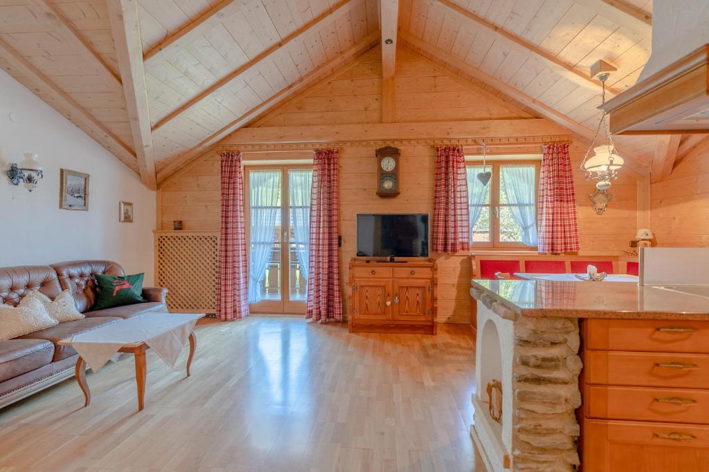 a large living room with a couch and a tv at Landhaus Waibel in Blaichach