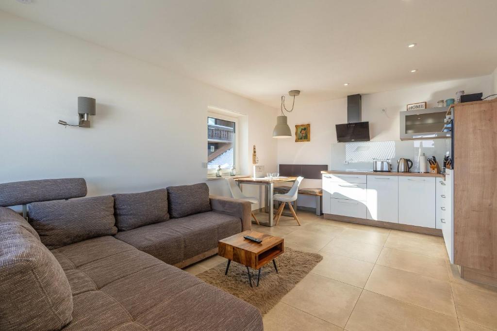 a living room with a couch and a kitchen at Fewo Blick in die Berge in Ofterschwang