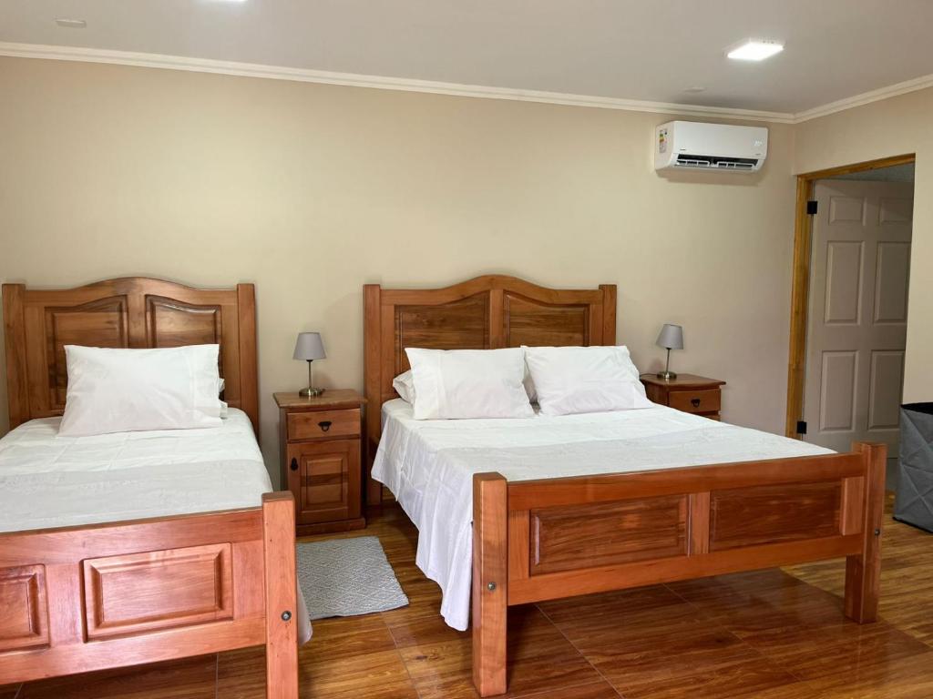 a bedroom with two beds and a tv on the wall at Hotel Parcela Tierra Fértil in Coltauco