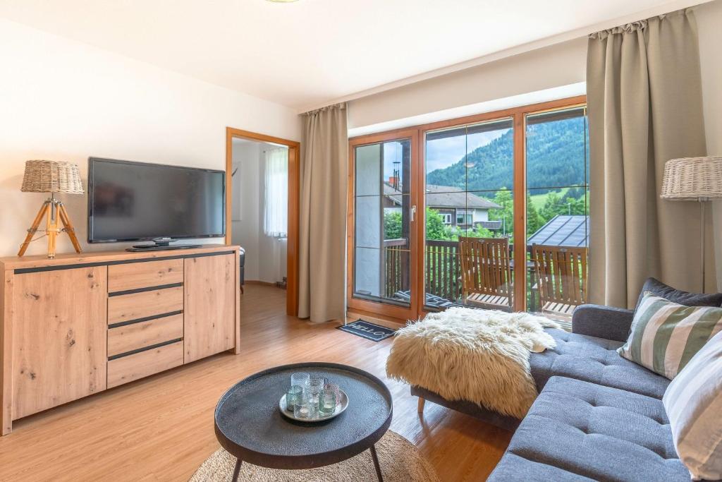 a living room with a couch and a tv at Gipfelliebe in Bad Hindelang