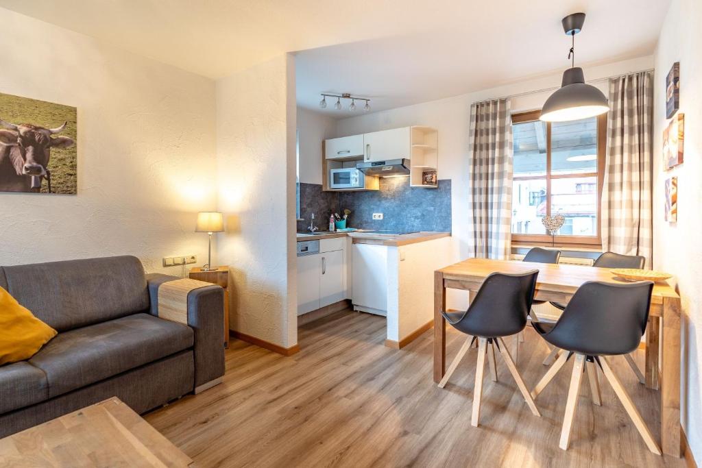 a living room and kitchen with a couch and a table at Bergfriede in Bad Hindelang