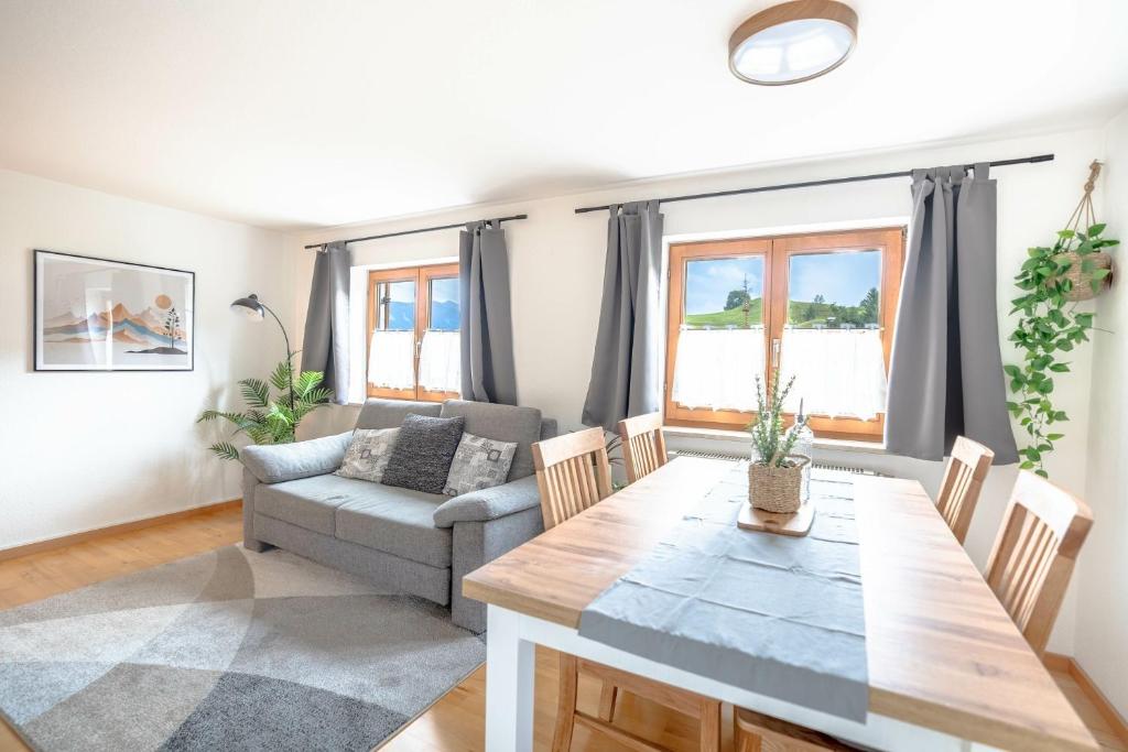 ein Wohnzimmer mit einem Tisch und einem Sofa in der Unterkunft Stolz 2 in Blaichach