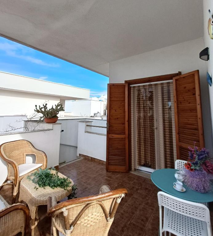 a balcony with a table and chairs and a kitchen at Fimar in Torre Lapillo