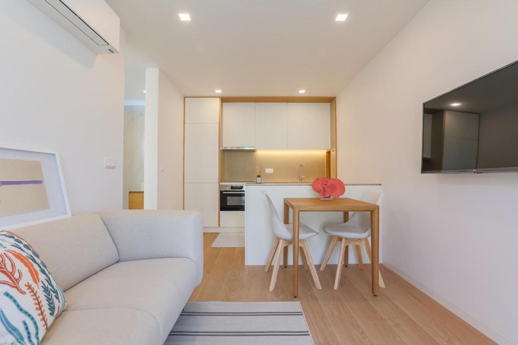 a living room with a couch and a table at D'AUSE - New Modern Apt - 150m to Beach & Center in Esposende