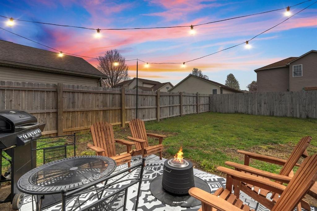 a backyard with a grill and chairs and a fire pit at Spacious King Suite, Game Room, Patio, Firepit in Lexington