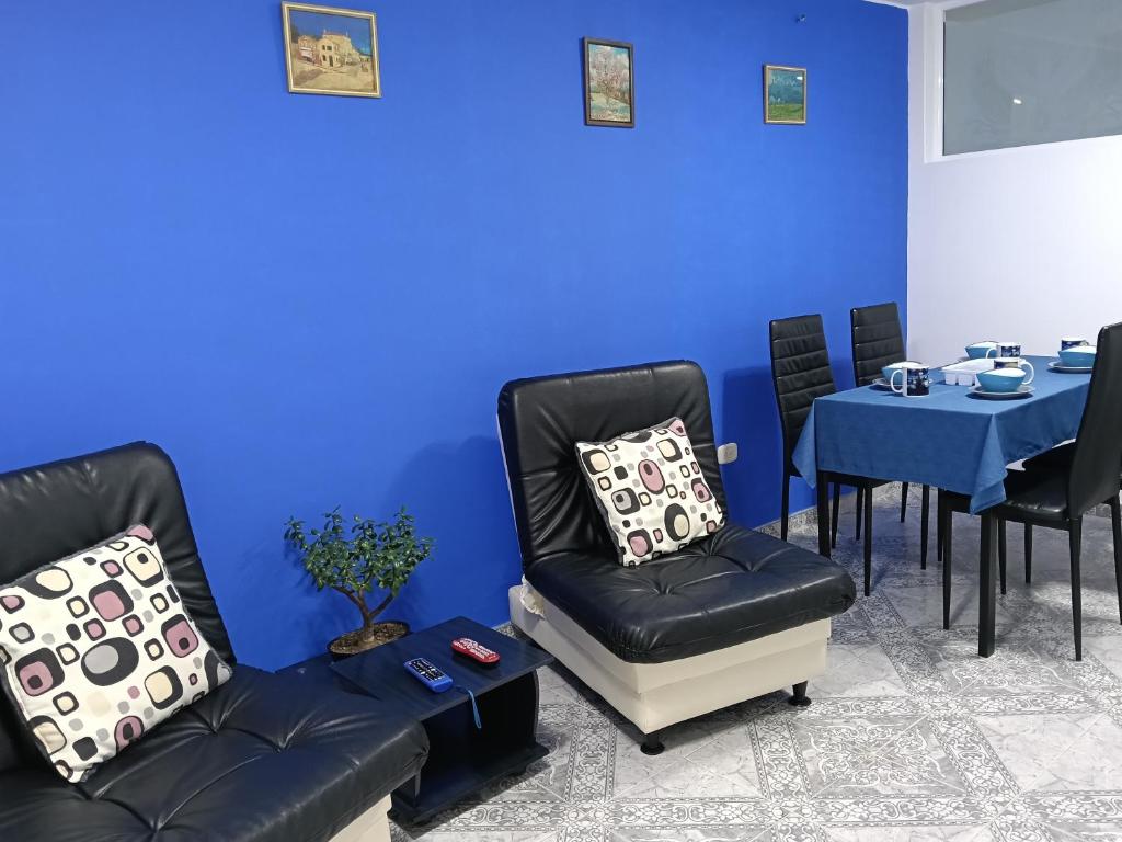 a blue room with two chairs and a table at Van Gogh Duitama in Duitama