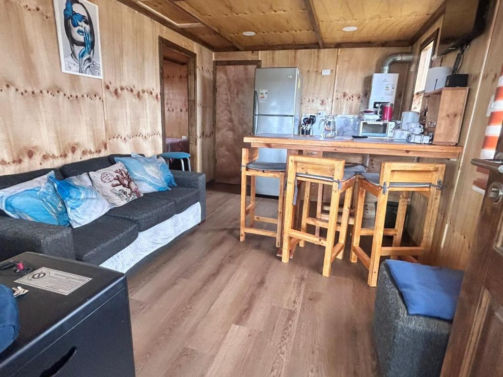 a living room with a couch and a kitchen at Villa Lagunitas in Puerto Montt