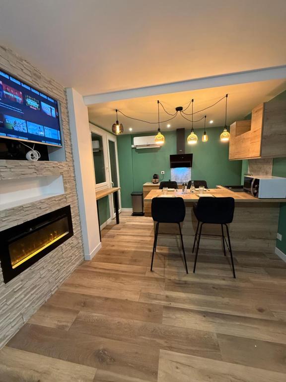 a dining room with a table and chairs and a fireplace at loyika , résidence avec caméra et digicode possibilité location voiture Mercedes ,garage ,climatisation ,cheminée, Netflix, petit déjeuner , repas du soir fondue, raclette , barbecue sur demande in Albertville