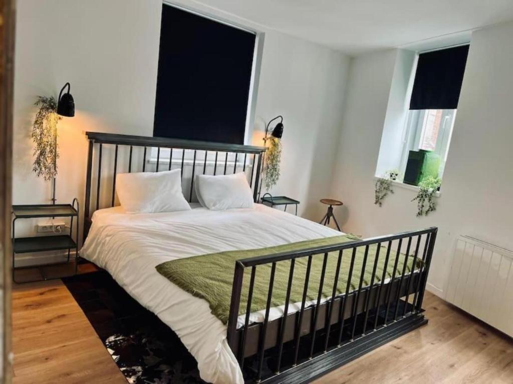 a bed in a bedroom with two windows at Chic vintage apartment in Spa in Spa